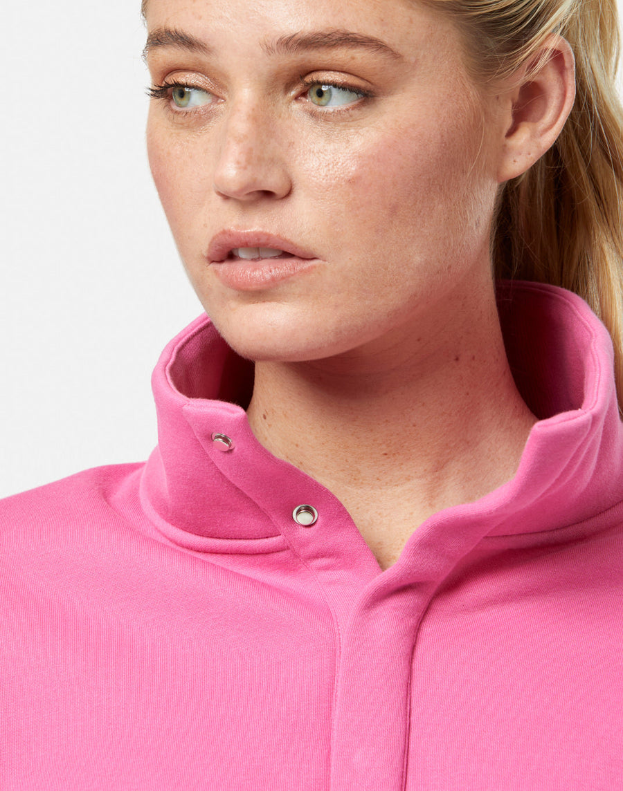 Close-up of a person wearing a pink jacket with a plain background